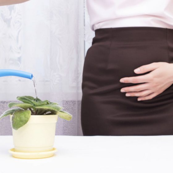 Mulher com dor pélvica regando uma planta